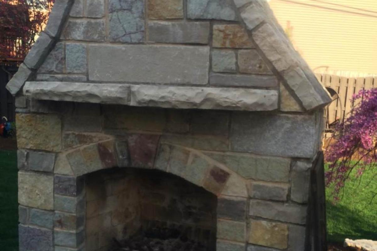A natural stone outdoor fireplace built by WJC Construction