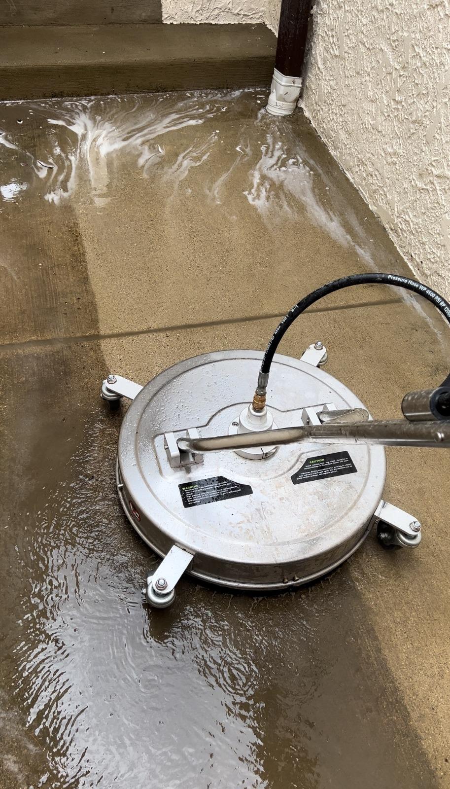 Power washing. Concrete cleaned with a surface cleaner, half done.